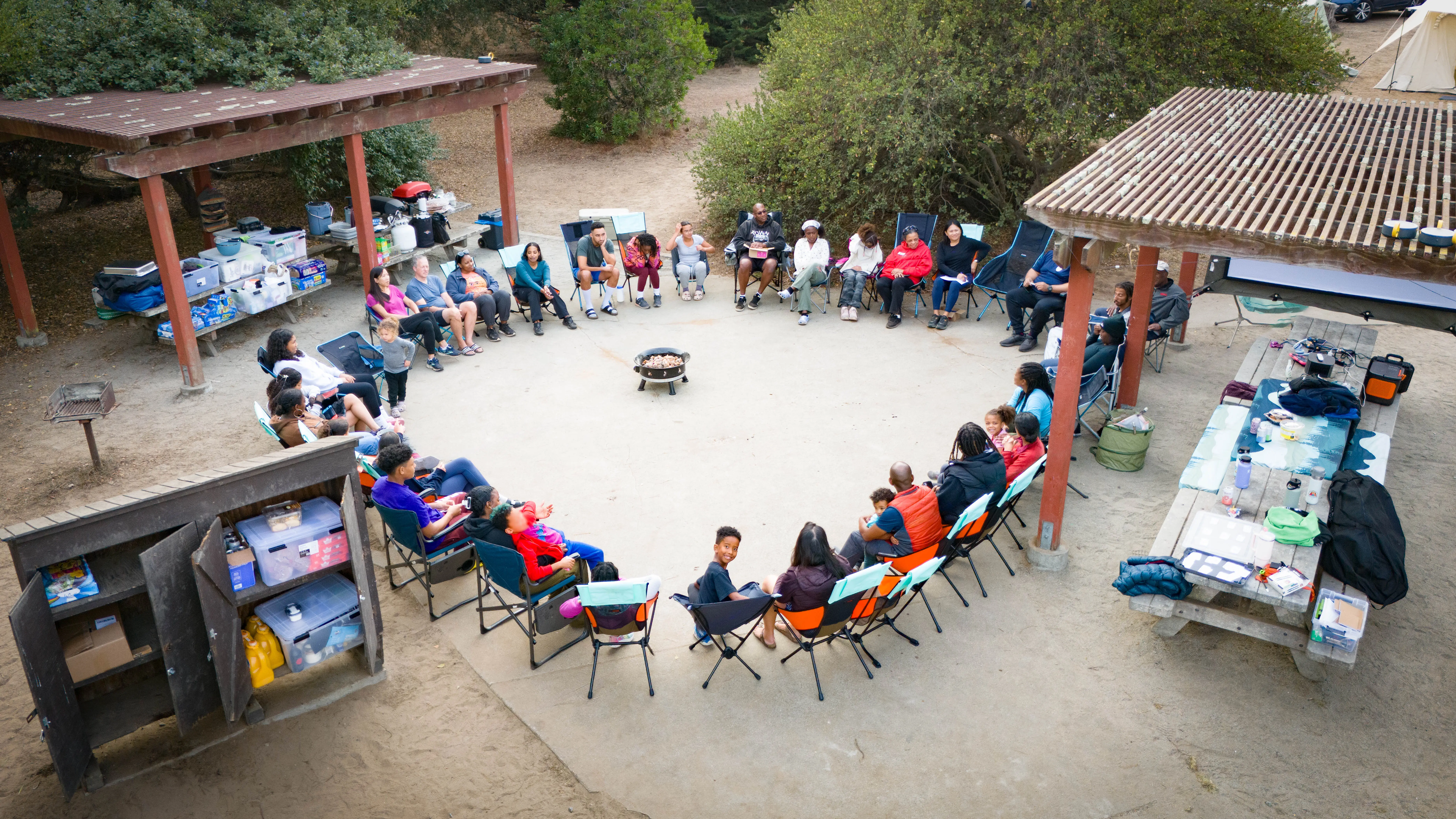 Group of Outdoorithm Collective members gathered in a circle at camp